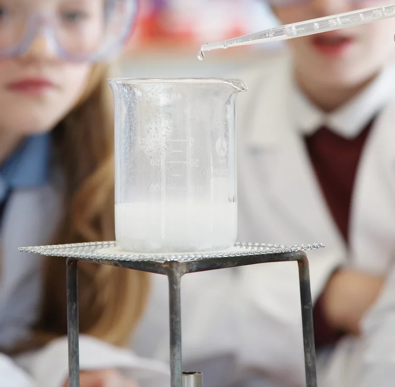 uczniowie przeprowadzają eksperyment na zajęciach z chemii